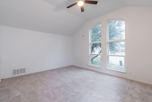 additional living space featuring light carpet, baseboards, visible vents, a ceiling fan, and vaulted ceiling