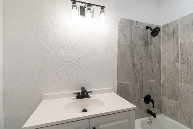 bathroom with  shower combination, vanity, and a textured wall