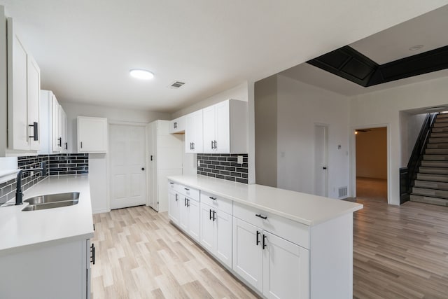 kitchen featuring light countertops, white cabinetry, and a sink