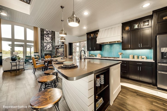 1231 Streamside Dr, Prosper, TX 75078 - kitchen featuring premium range hood, stainless steel appliances, open floor plan, wood finished floors, and recessed lighting