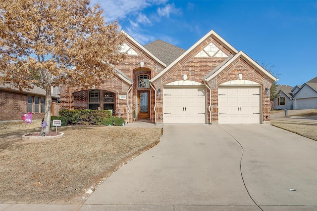 view of front of property with a shingled roof, concrete driveway, brick siding, and a garage