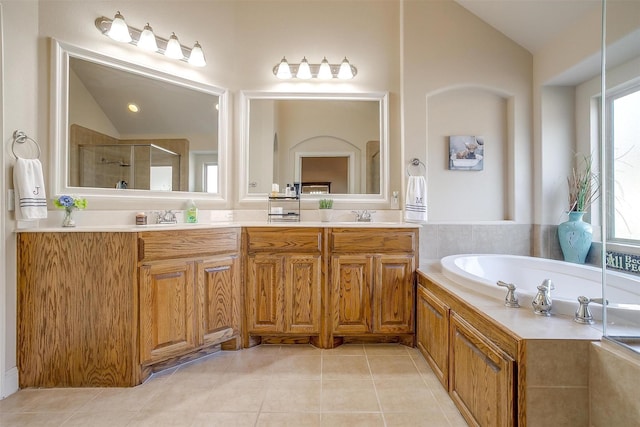 bathroom with tile patterned flooring, a sink, vaulted ceiling, double vanity, and a stall shower