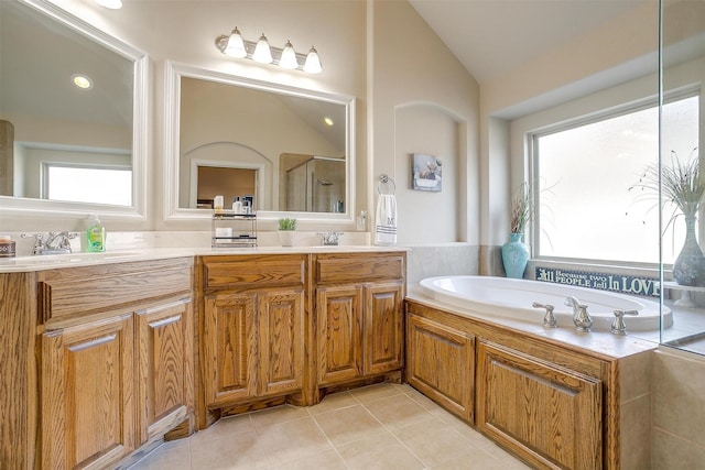 bathroom with double vanity, lofted ceiling, a sink, a shower stall, and tile patterned flooring