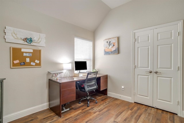 home office featuring vaulted ceiling, baseboards, and wood finished floors