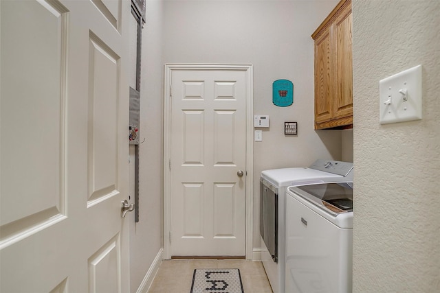 laundry room with washer and dryer, cabinet space, baseboards, and light tile patterned floors