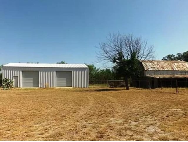 view of yard with a garage and an outbuilding