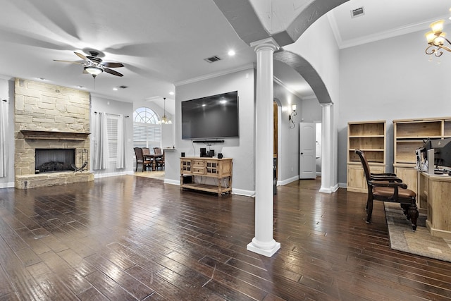 living room with arched walkways, dark wood-style flooring, visible vents, and ornate columns