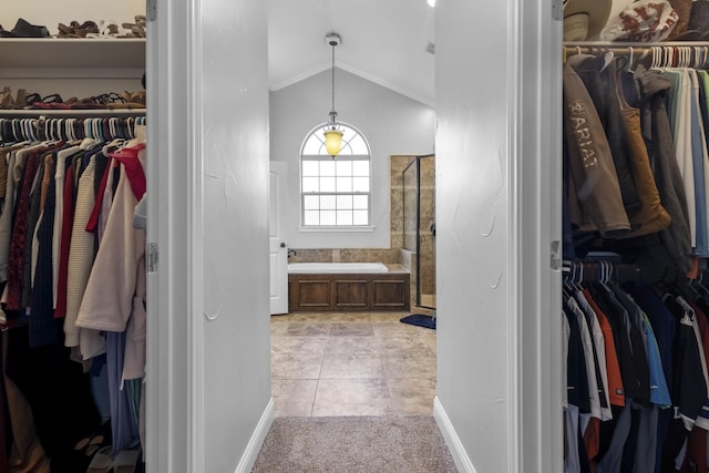 walk in closet featuring lofted ceiling, light tile patterned floors, and light colored carpet