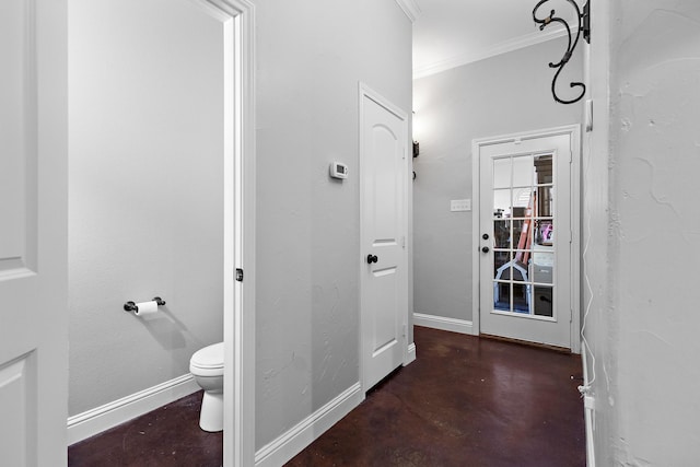 bathroom with ornamental molding, baseboards, finished concrete flooring, and toilet