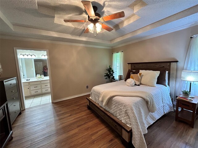 122 Lakeway Ln, Gun Barrel City, TX 75156 - bedroom with a tray ceiling, wood finished floors, baseboards, ensuite bathroom, and a textured ceiling