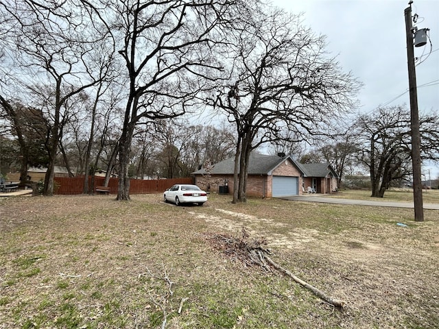 view of front facade with a front yard, brick siding, and fence