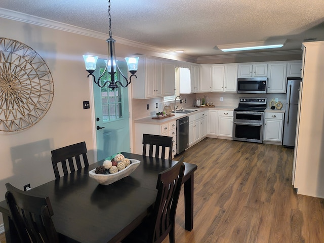 122 Lakeway Ln, Gun Barrel City, TX 75156 - kitchen featuring appliances with stainless steel finishes, a sink, crown molding, a chandelier, and dark wood-type flooring