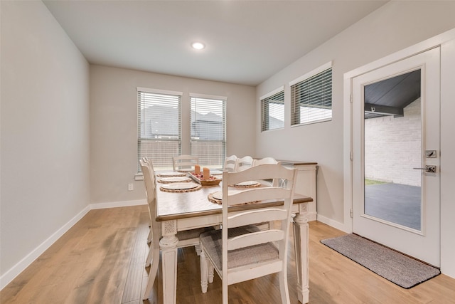 dining space with baseboards and light wood-style floors