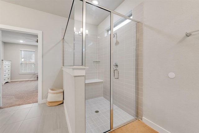 bathroom with a stall shower, baseboards, and tile patterned floors