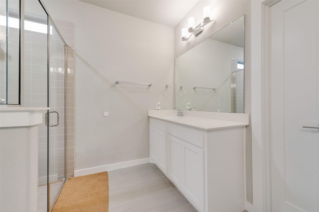 bathroom with tile patterned flooring, a shower stall, baseboards, and vanity