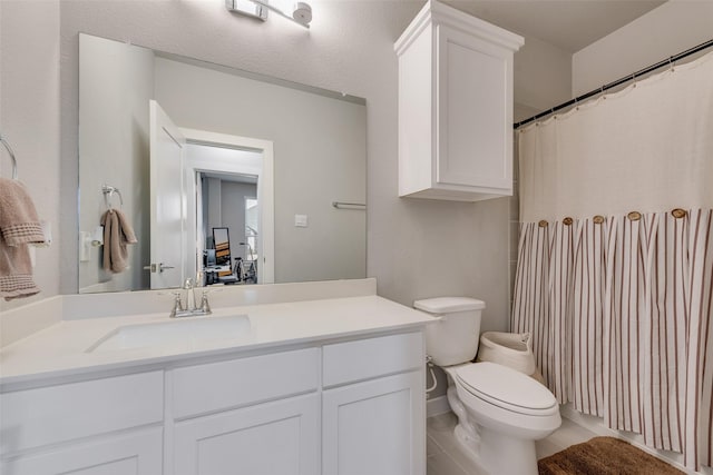 bathroom with toilet, tile patterned flooring, and vanity