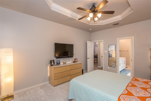 bedroom featuring light colored carpet, a tray ceiling, visible vents, and ornamental molding