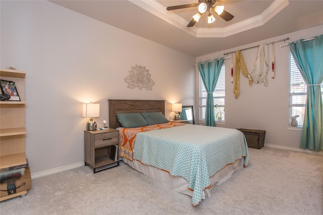 bedroom featuring crown molding, a raised ceiling, light carpet, ceiling fan, and baseboards