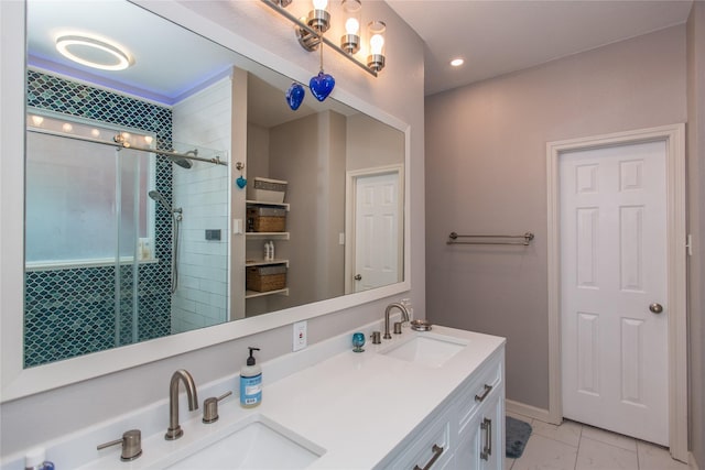 bathroom with double vanity, marble finish floor, a shower stall, and a sink