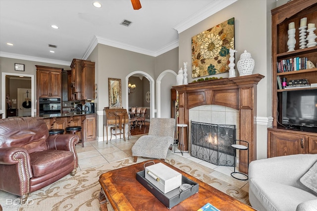 living area with arched walkways, ornamental molding, visible vents, and recessed lighting