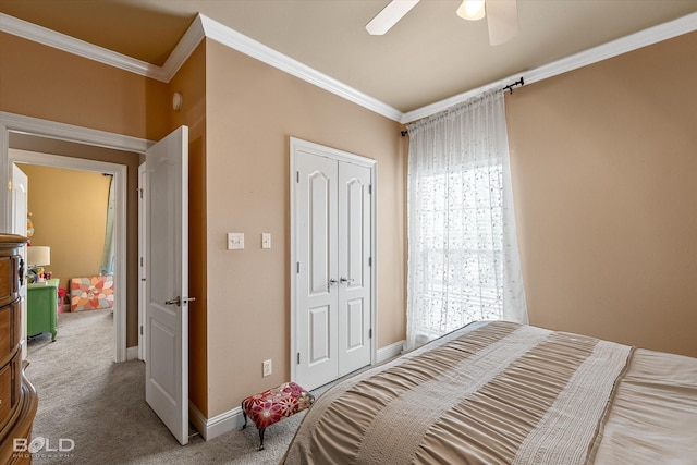 carpeted bedroom with ceiling fan, ornamental molding, a closet, and baseboards