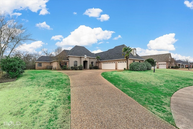 french provincial home featuring driveway, a front lawn, an attached garage, and brick siding