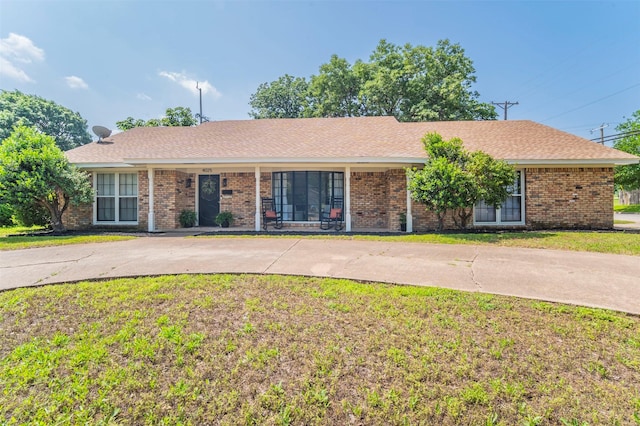 ranch-style home featuring brick siding and a front lawn