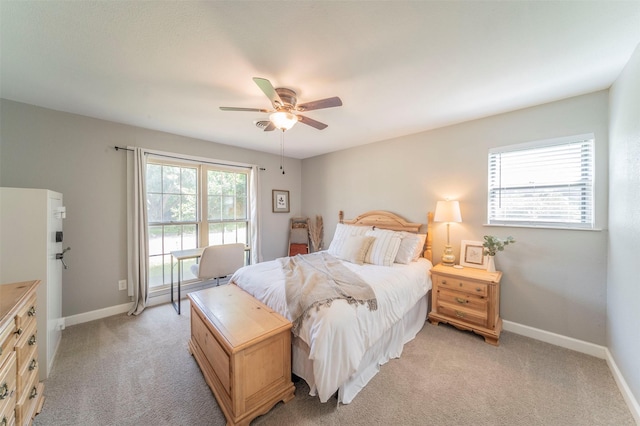 bedroom with light carpet, ceiling fan, baseboards, and freestanding refrigerator