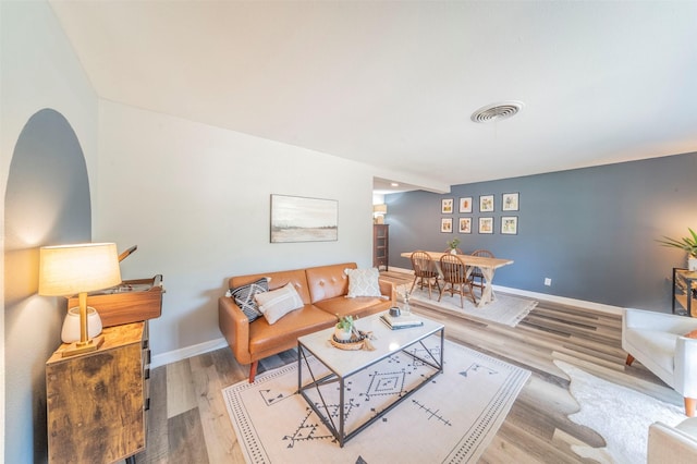 living area with light wood-style floors, baseboards, and visible vents