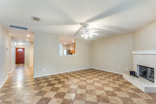 unfurnished living room with baseboards, a fireplace, visible vents, and a ceiling fan