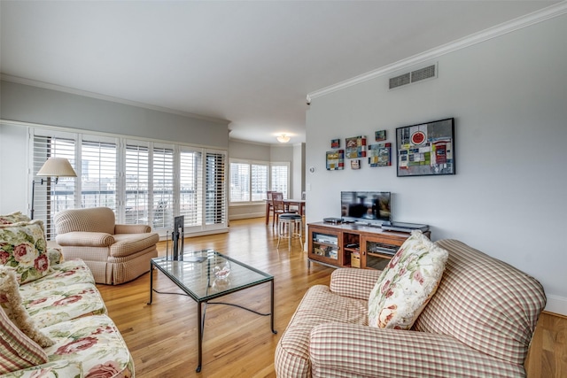 living room with crown molding, visible vents, and wood finished floors