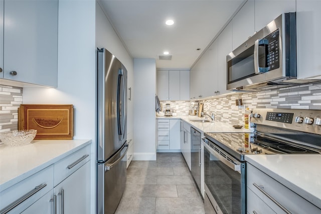 kitchen with light countertops, appliances with stainless steel finishes, a sink, and visible vents