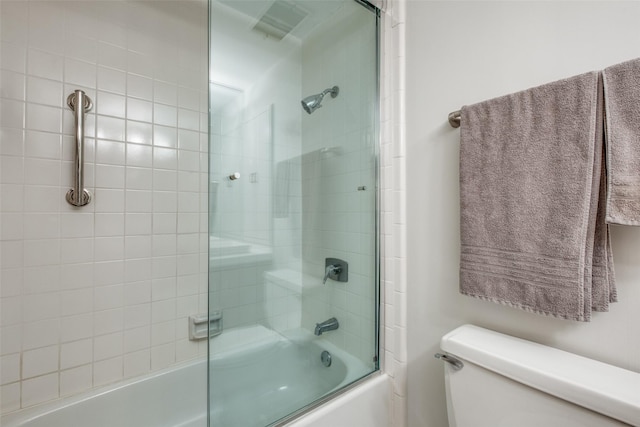 full bath featuring combined bath / shower with glass door and toilet