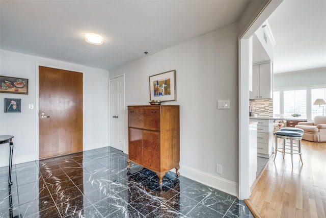 interior space featuring marble finish floor and baseboards