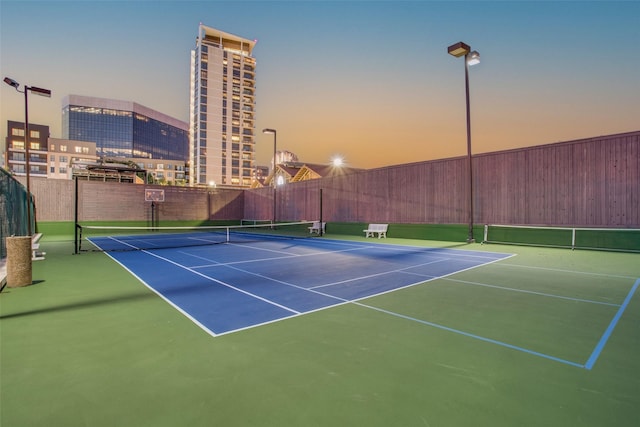 view of sport court with fence and a city view