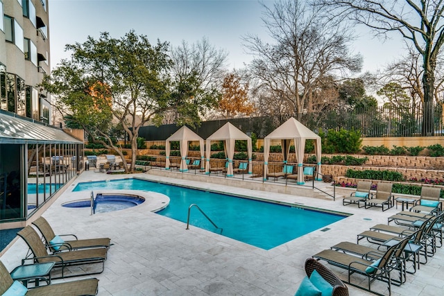 community pool featuring a patio area, a hot tub, fence, and a gazebo