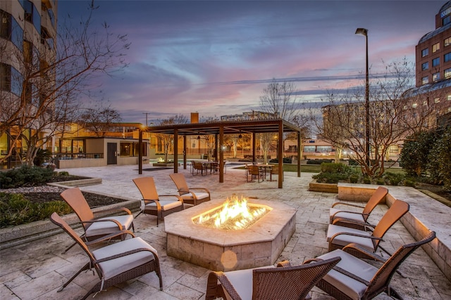 patio terrace at dusk featuring a fire pit