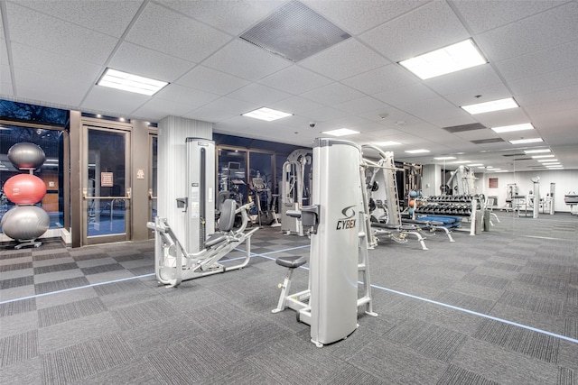 workout area with carpet floors, visible vents, and a paneled ceiling