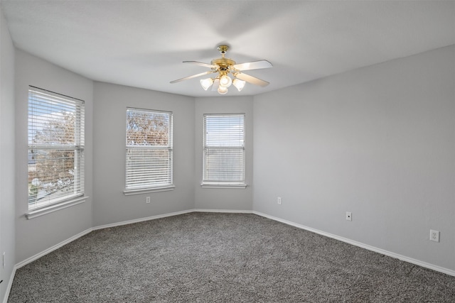 carpeted empty room featuring a ceiling fan and baseboards