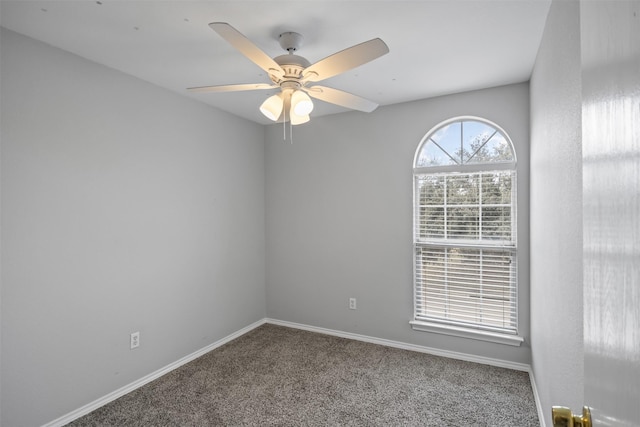 carpeted spare room with baseboards and a ceiling fan