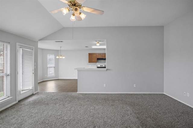 unfurnished living room featuring dark colored carpet, visible vents, vaulted ceiling, baseboards, and ceiling fan with notable chandelier