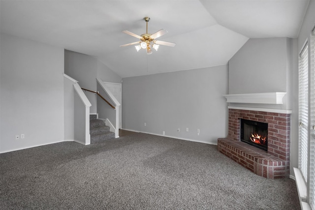 unfurnished living room featuring ceiling fan, stairway, vaulted ceiling, carpet flooring, and a fireplace