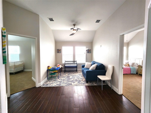 living room with dark wood-style flooring, visible vents, vaulted ceiling, and baseboards