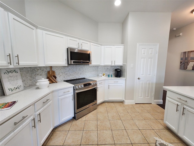 kitchen featuring light tile patterned floors, stainless steel appliances, white cabinetry, light countertops, and decorative backsplash