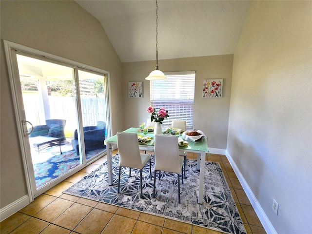 dining area with lofted ceiling, tile patterned flooring, and baseboards