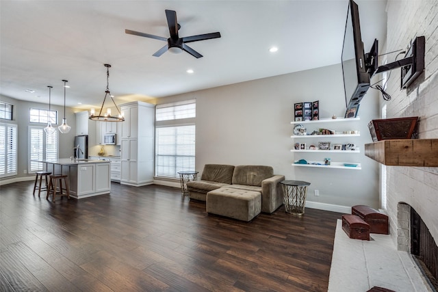 living room with dark wood-style flooring, recessed lighting, a fireplace with flush hearth, a ceiling fan, and baseboards