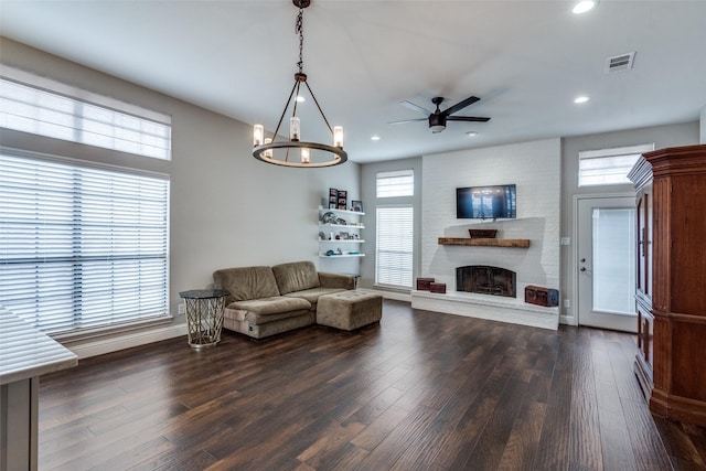 living area with a fireplace, dark wood finished floors, visible vents, and recessed lighting