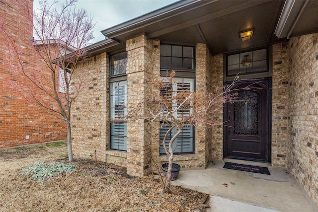 view of exterior entry with brick siding