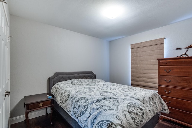 bedroom featuring dark wood-style floors and baseboards