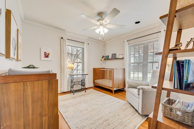 living area with ceiling fan, wood finished floors, and crown molding